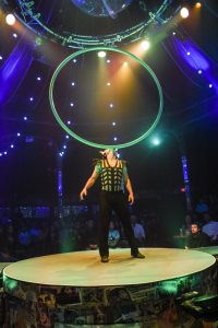 Circus performer holding a large ring on his face